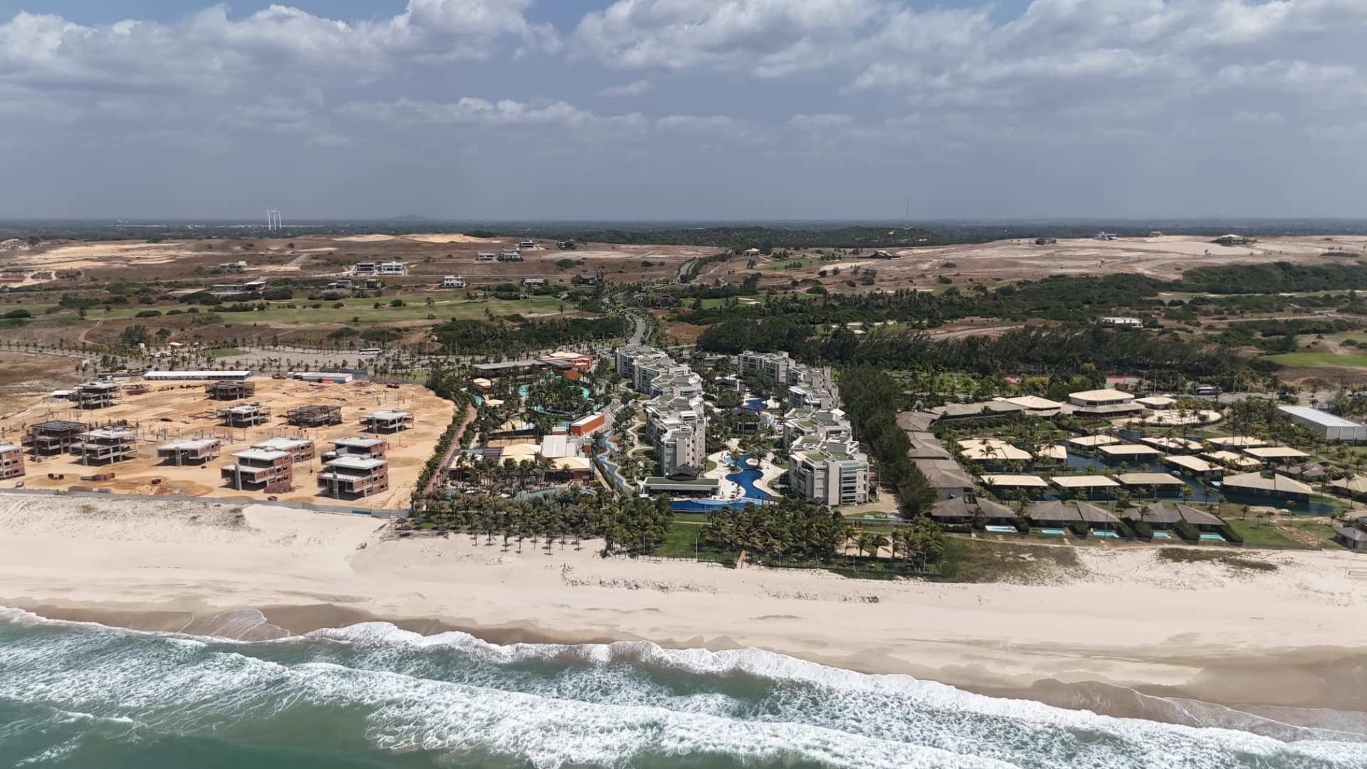 Vista aérea real dos edifícios, piscinas e praia do Aquiraz Riviera